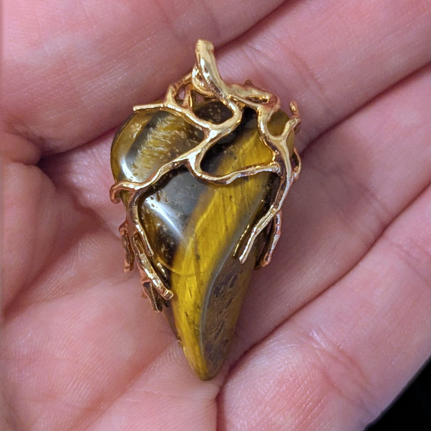 Wire-wrapped pendant featuring polished tiger's eye stone